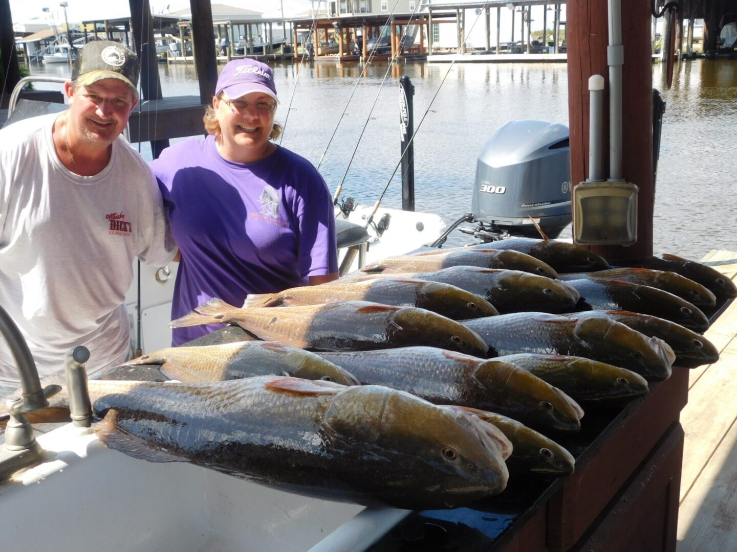 Two people standing next to a table with fish.