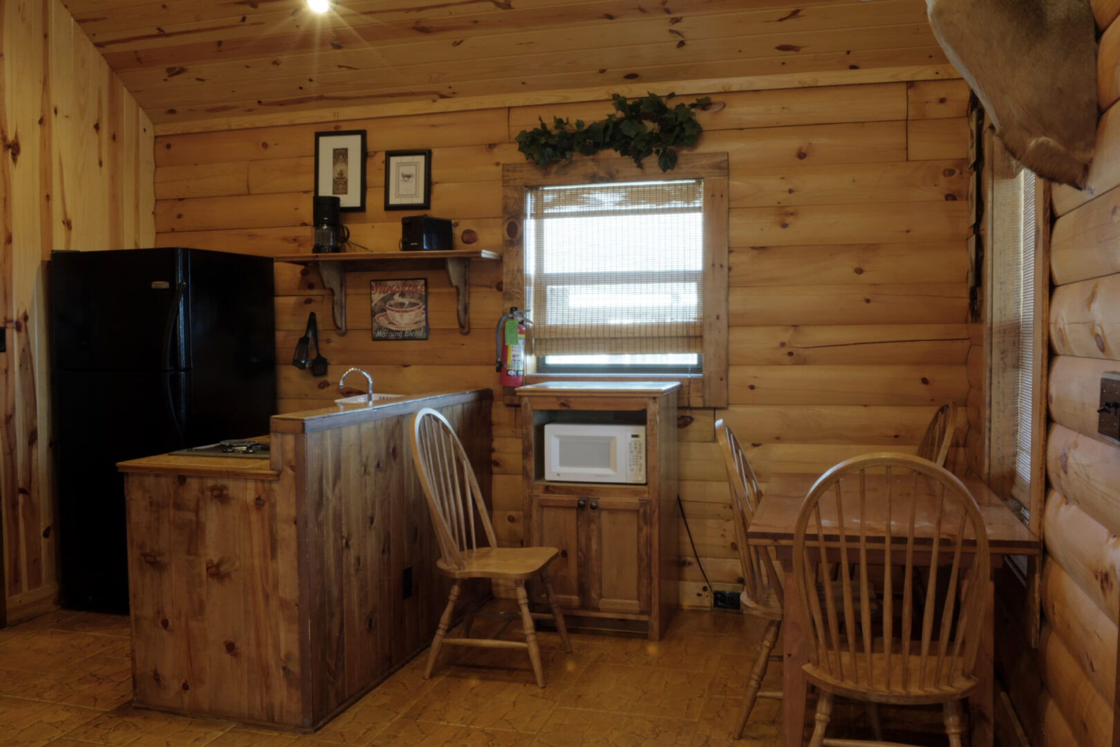 A room with wooden furniture and a microwave.