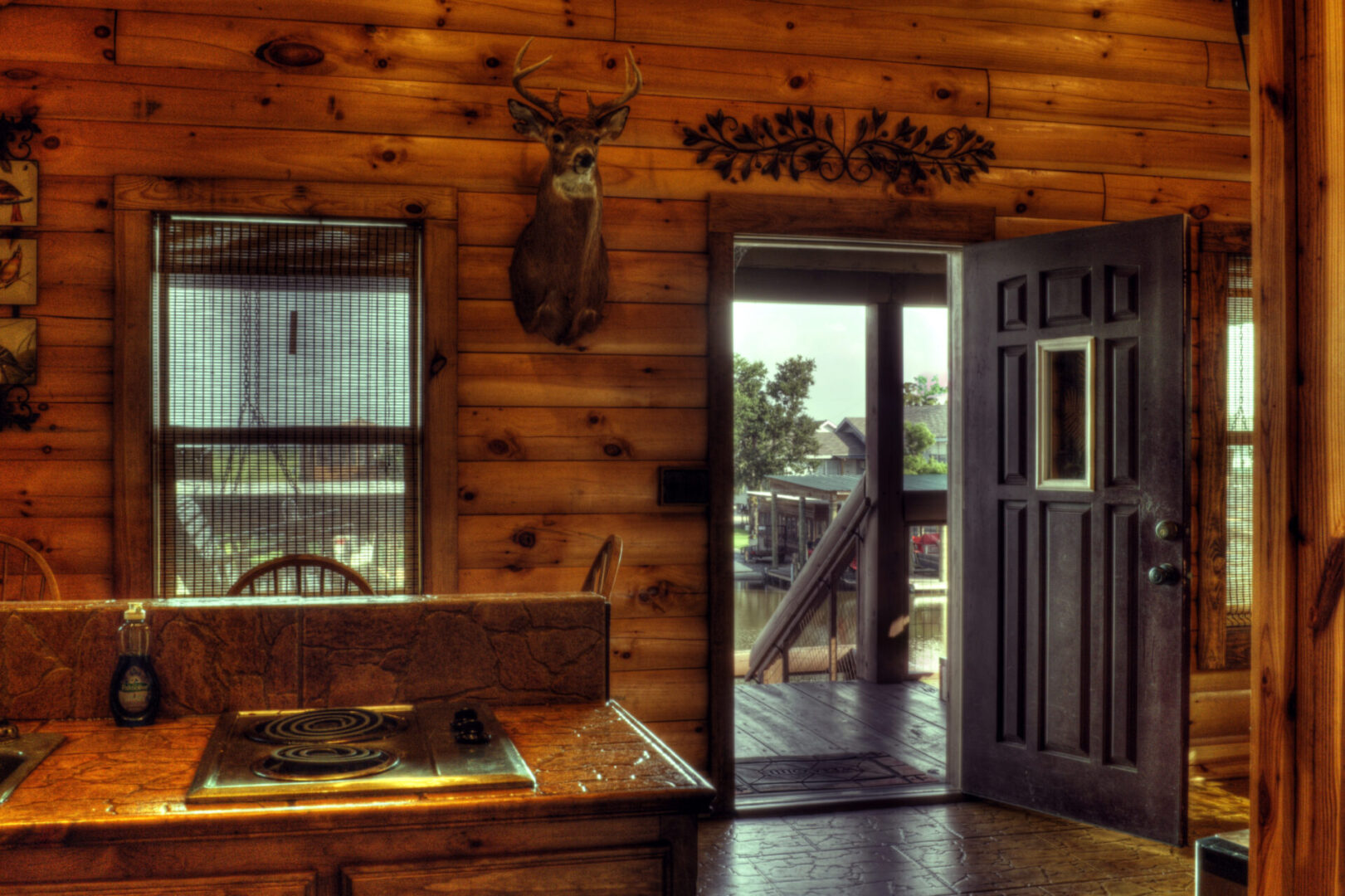 A cabin with wood walls and a door open.