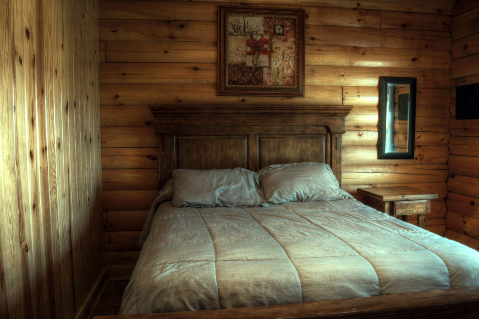 A bed room with a wooden headboard and two night stands