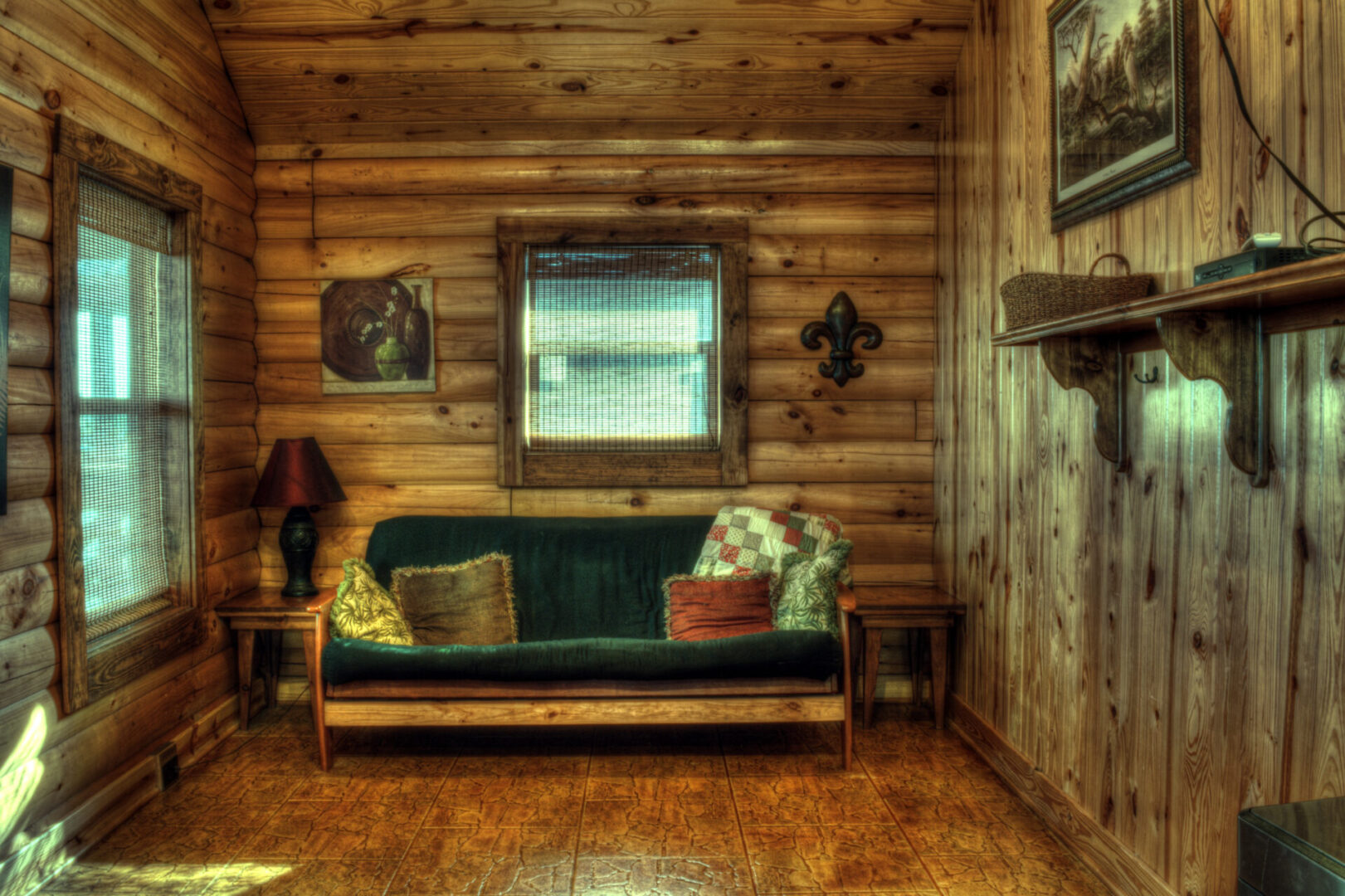 A couch in the corner of a room with wood paneling.